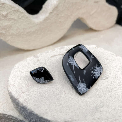 Keelin Design · Enchanta Asymmetrisch · Statement Geometrische Oorstekers · Witte Bloemen (close-up)